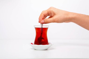 Beyaz arka planda bir fincan çay içen kadın var.. 