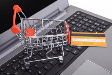 Masada küçük bir alışveriş arabası var. İnternet alışveriş kavramı.