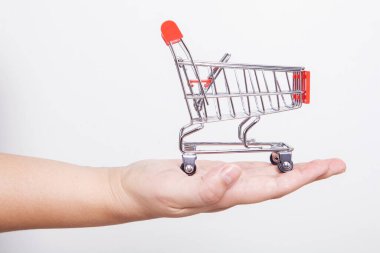 İnternetten alışveriş yapan kadının elindeki küçük oyuncak alışveriş arabası. İnternet alışveriş kavramı.