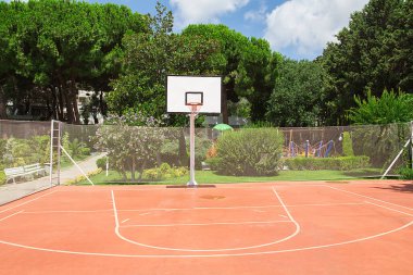 Açık hava halk basketbol sahası ve kırmızı lastik oyun alanı.