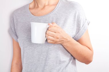 Genç kadın beyaz arka planda kahve içiyor..