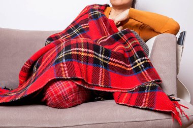 Kadın battaniyeye sarılmış. Kadın hasta ve hava da soğuk..