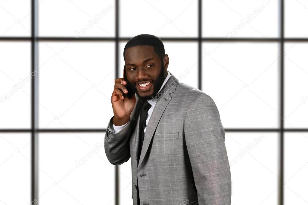 Friendly businessman has phone conversation.