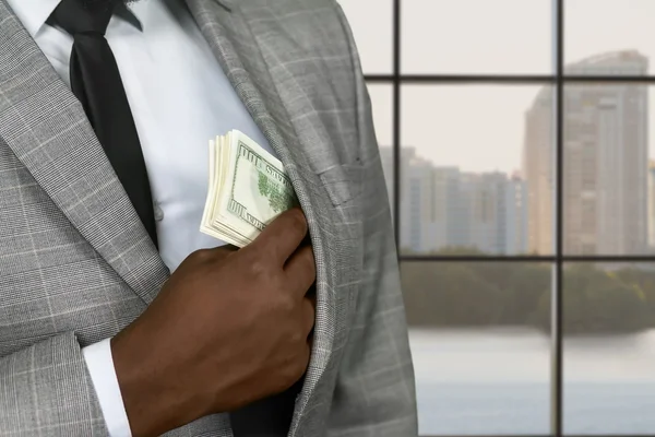 Afro-Büroleiter versteckt Geld. — Stockfoto