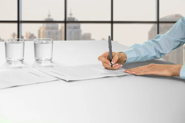 Female office employee signing papers.