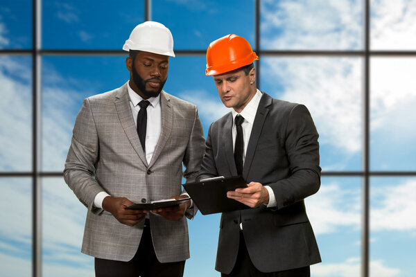 Two architects on sky background.