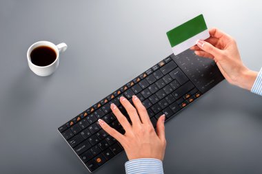 Womans hands holding credit card.