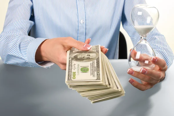 Lady holds hourglass and money. — Stock Photo, Image