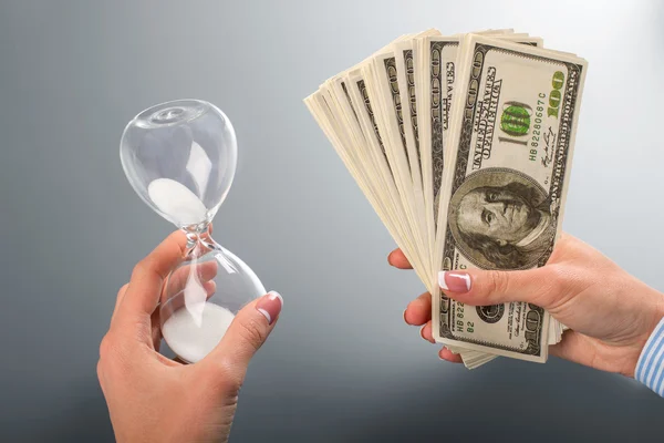 Ladys hourglass and dollar fan. — Stock Photo, Image