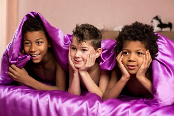 Tři usmívající se chlapci pod dekou. — Stock fotografie