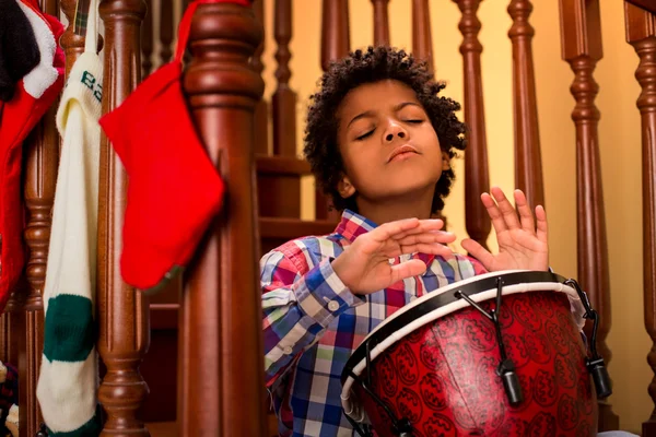 Enthusiastic darkskinned boy playing drum. — Stock Photo, Image