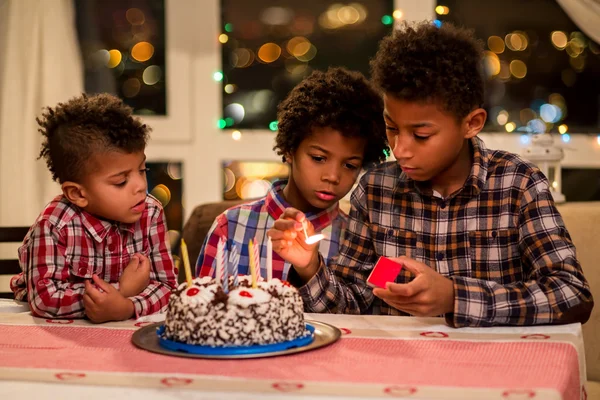 Crianças acendendo velas de aniversário . — Fotografia de Stock