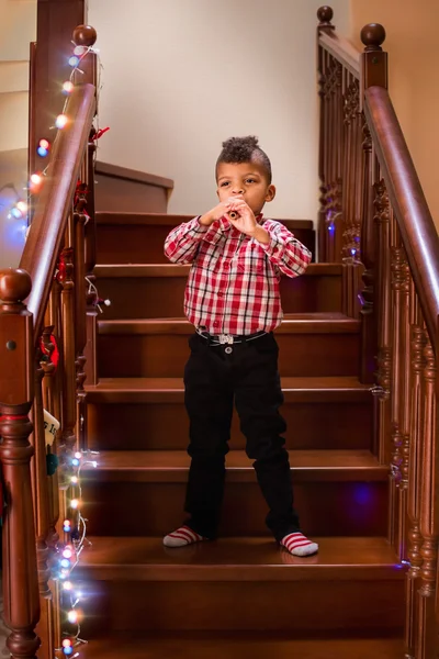 Standing black kid plays flute. — Stock Photo, Image