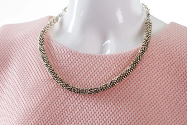 Delicate metal necklace on mannequin.