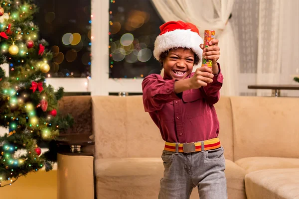 Afro chico celebración Navidad petard . — Foto de Stock