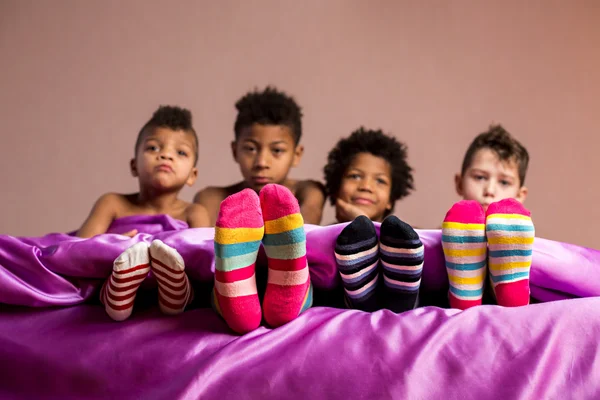 Kinder in bunten Socken sitzen. — Stockfoto