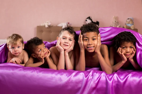 Sorrindo crianças cansadas na cama . — Fotografia de Stock