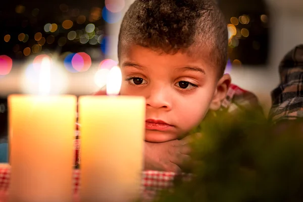 Niño triste al lado de las velas de Navidad . — Foto de Stock