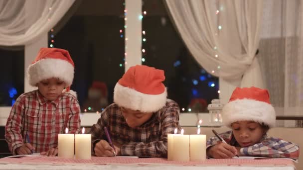 Weinig Santas schrijft een brief. — Stockvideo