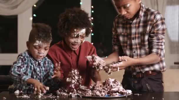 Afro niños codiciosamente comer pastel . — Vídeos de Stock