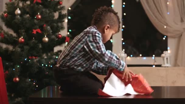 Enfant déballer cadeau sur la table . — Video