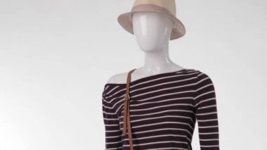 Female mannequin wearing striped top.