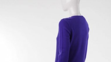 Mannequin in blue sweater turning.