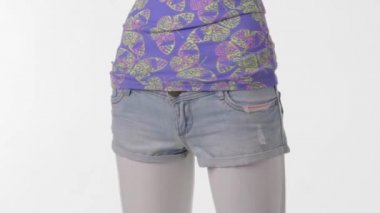 Mannequin in denim shorts turning.