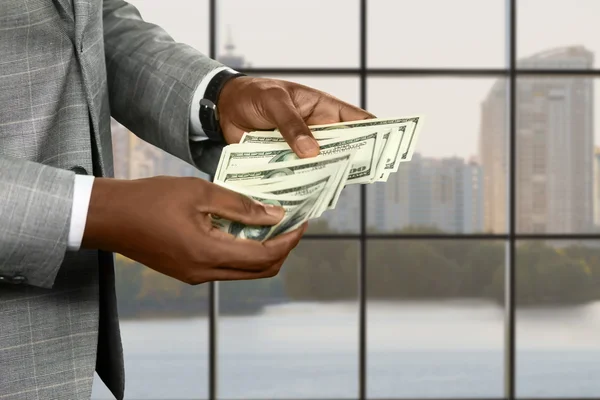 Afro zaken Mans handen tellen cash. — Stockfoto