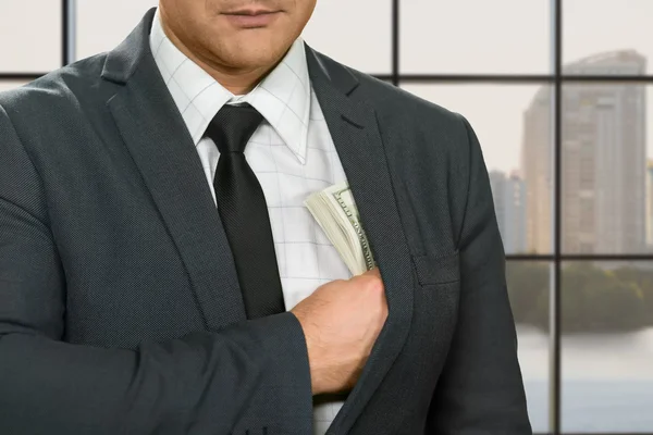 Biznesmen ukrywa dolarów do kurtki. — Zdjęcie stockowe