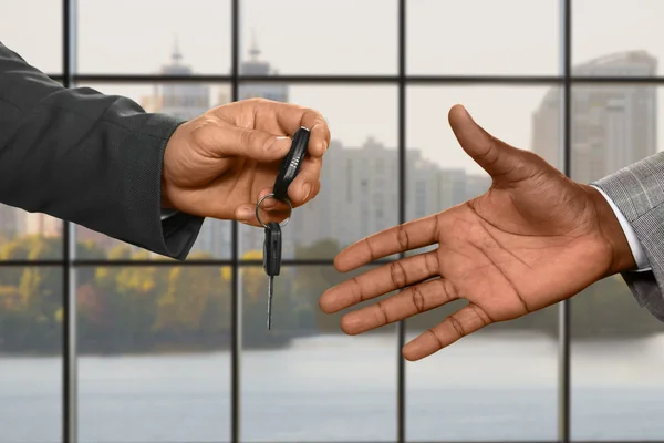 Homens de negócios caucasianos mão dando chave . — Fotografia de Stock