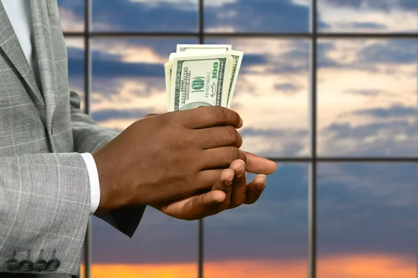 Dark skinned Mans hand houden cash. — Stockfoto