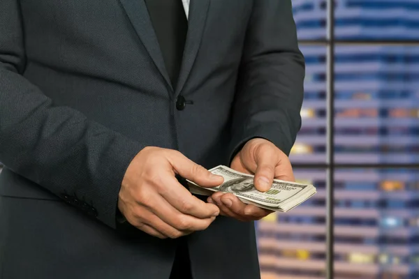 Männliche Hände, die amerikanische Dollars halten. — Stockfoto