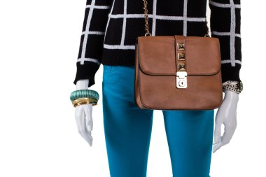 Turkuaz pantolon ile kahverengi çanta.