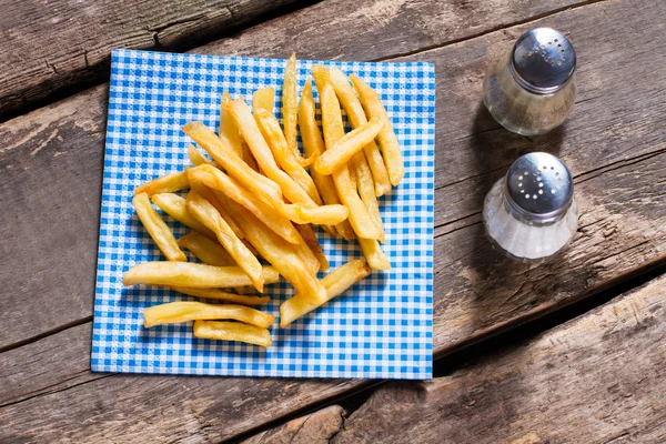 Fritas em guardanapo e caixa de pimenta . — Fotografia de Stock