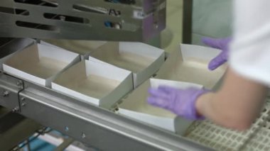 Konveyör üzerinde küçük açılmış kutular.