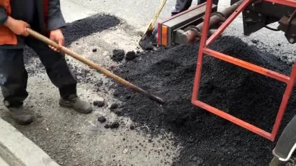 Arbeiter mit Schaufeln reparieren Asphalt. — Stockvideo