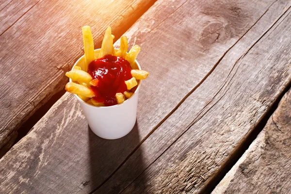 Xícara de batatas fritas com ketchup . — Fotografia de Stock