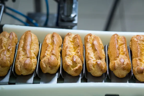 Línea transportadora con eclairs . —  Fotos de Stock