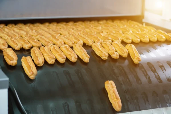 Eclairs en el transportador grande . — Foto de Stock