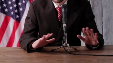 Mikrofona konuşuyor.