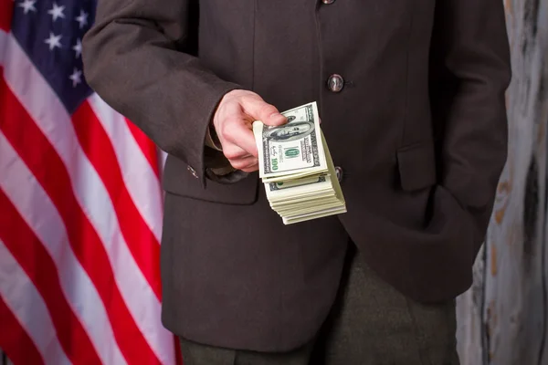 Homme en costume tenant des dollars . — Photo