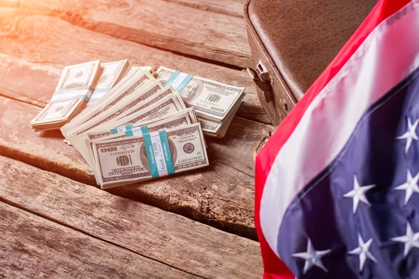 Bandera americana, efectivo y maleta . — Foto de Stock