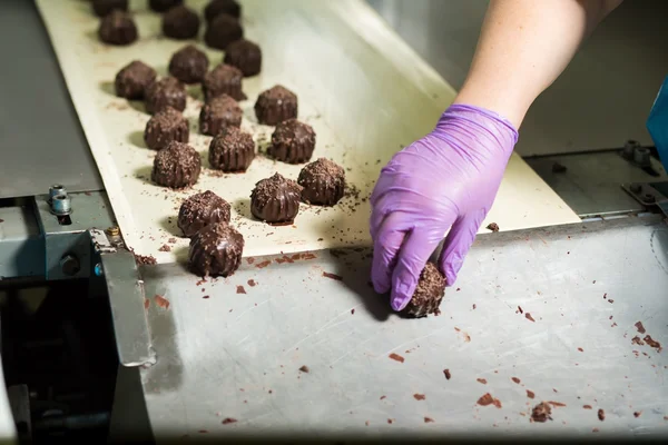 Dunkle Bonbons auf dem Förderband. — Stockfoto