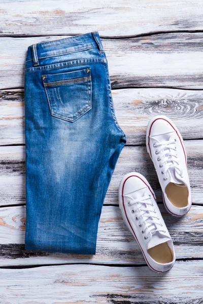 Складные джинсы и белые туфли . — стоковое фото