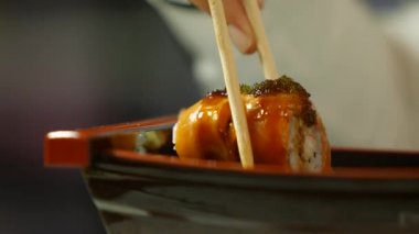 # Elleri çubuklarla suşi alıyor #.