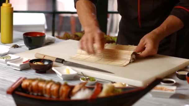 Männerhände schneiden Sushi-Rollen. — Stockvideo