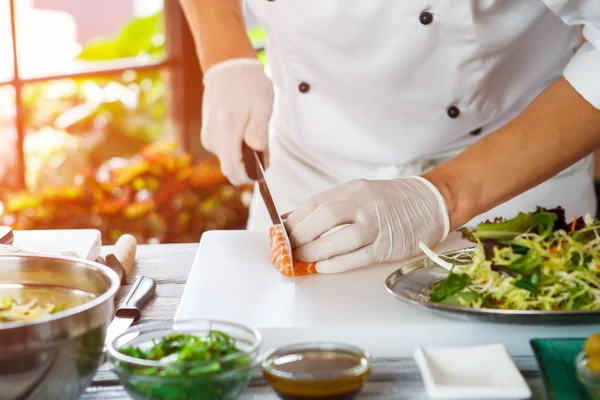 Hand med kniv skär fisk. — Stockfoto