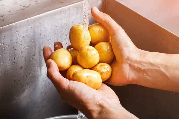 Mans hands washing potatoes. — Stock Photo, Image
