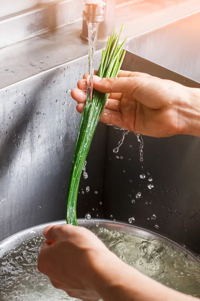 Mans tangan mencuci bawang hijau. — Stok Foto